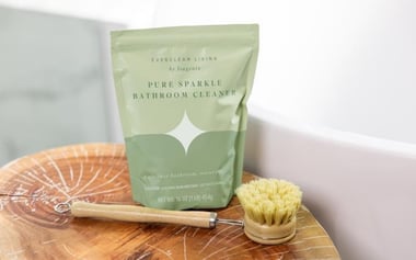 Everclean Living bathroom cleaner pouch with wooden scrub brush on a bathroom counter