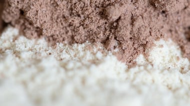 Close-up of blended protein powder in light and chocolate tones.