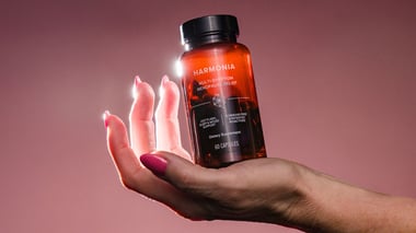 Person holding a stick pack labeled ‘Hydrate+ Hyaluronic Acid Total Body Hydration’ near the face.