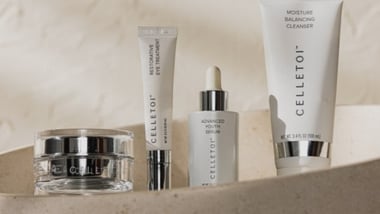 Celletoi skincare products arranged in a row on a textured surface, including jars and tubes labeled ‘Advanced Youth Serum,’ ‘Restorative Eye Treatment,’ and ‘Moisture Balancing Cleanser.’